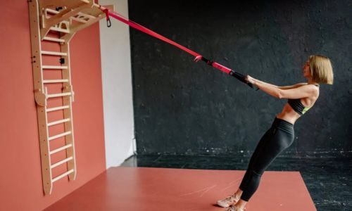 Mulher utilizando equipamento funcional em academia doméstica
